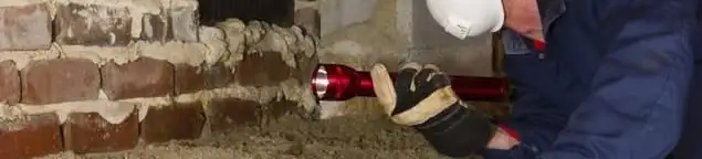 Pest control technician inspecting a crawl space for ant activity and entry points in Erie, PA
