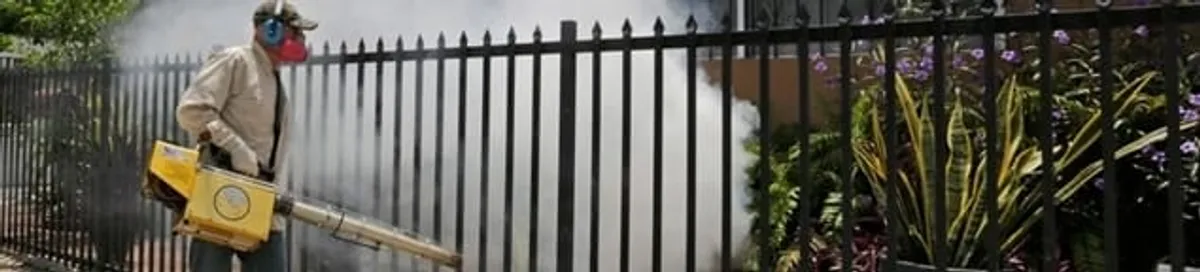 Mosquito control technician fogging a yard perimeter for mosquito reduction in Erie, PA